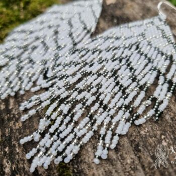 Long white beaded earrings in the shape of a feather