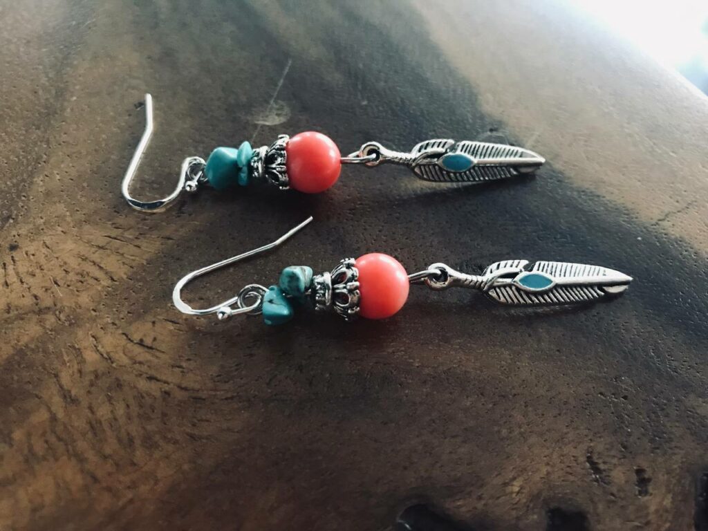 handcrafted earrings, featuring beautiful turquoise beads and a delicate feather charm in an enchanting Native American style